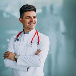Young handsome physician in a medical robe with stethoscope